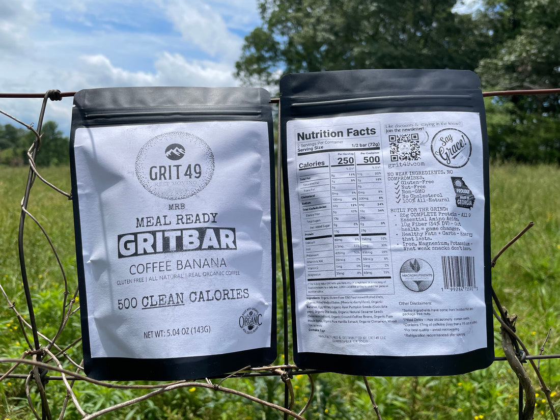 Two GRITBAR packages resting on a wire fence in a country pasture