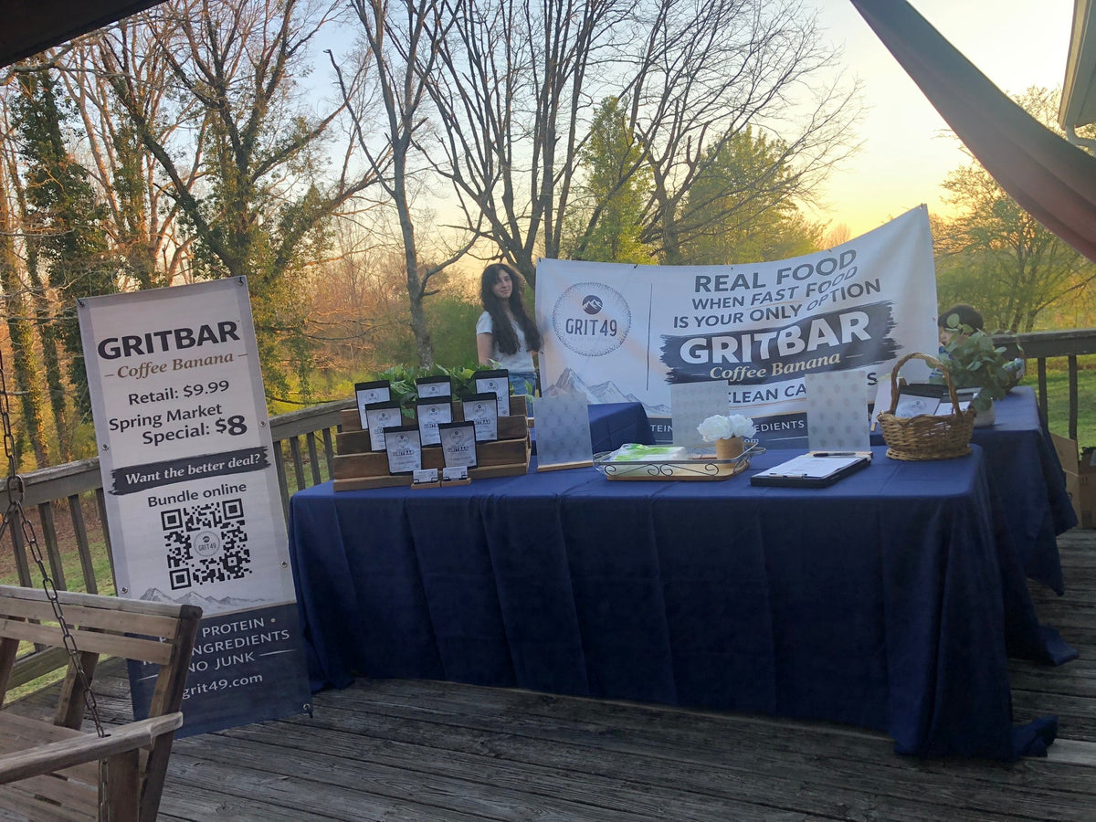 Founder preparing GRITBAR inventory and booth setup for spring market event
